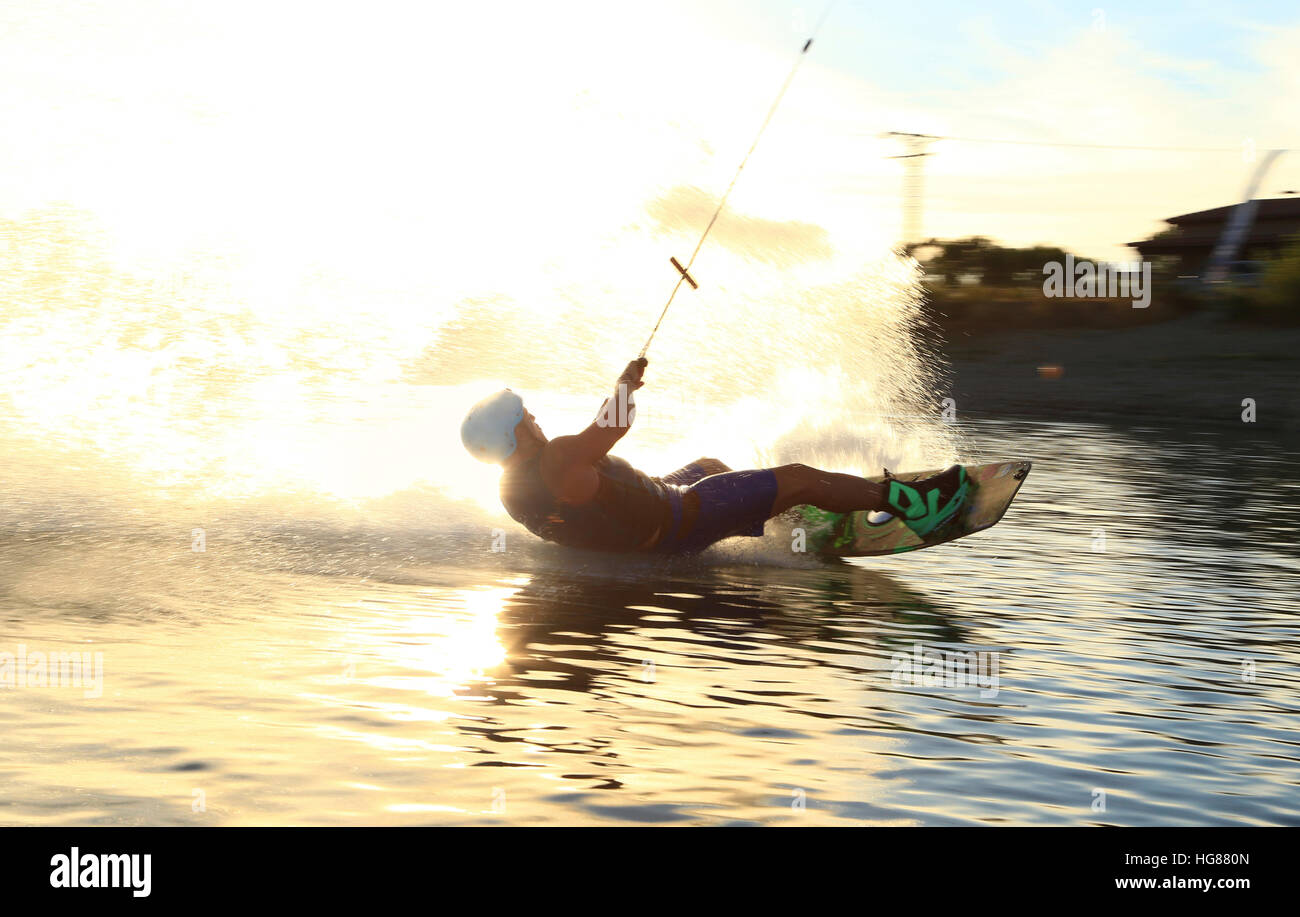 Hombre de kiteboarding en el lago al atardecer. Foto de stock
