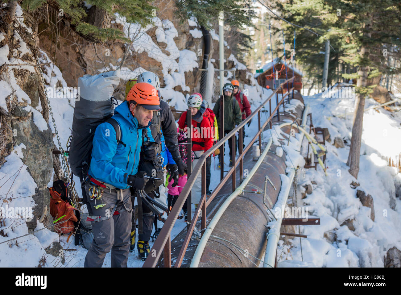 Ouray, Colorado - escaladores de hielo mirar a lo largo de rutas de escalada en Ouray Ice Park. Las tuberías y boquillas se usan para crear y mantener el hielo. Foto de stock