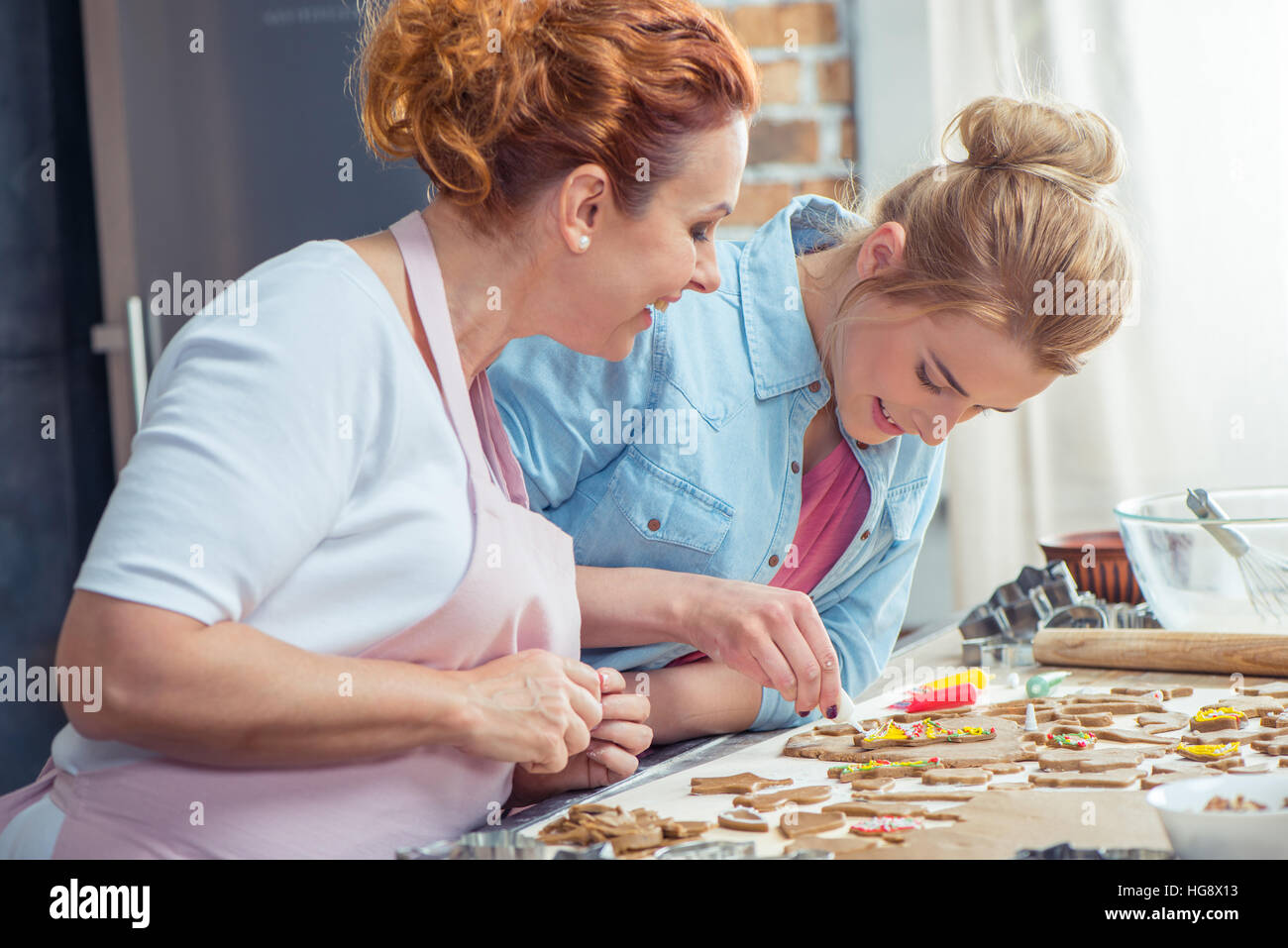 Madre e hija haciendo galletas de Navidad en la cocina Foto de stock