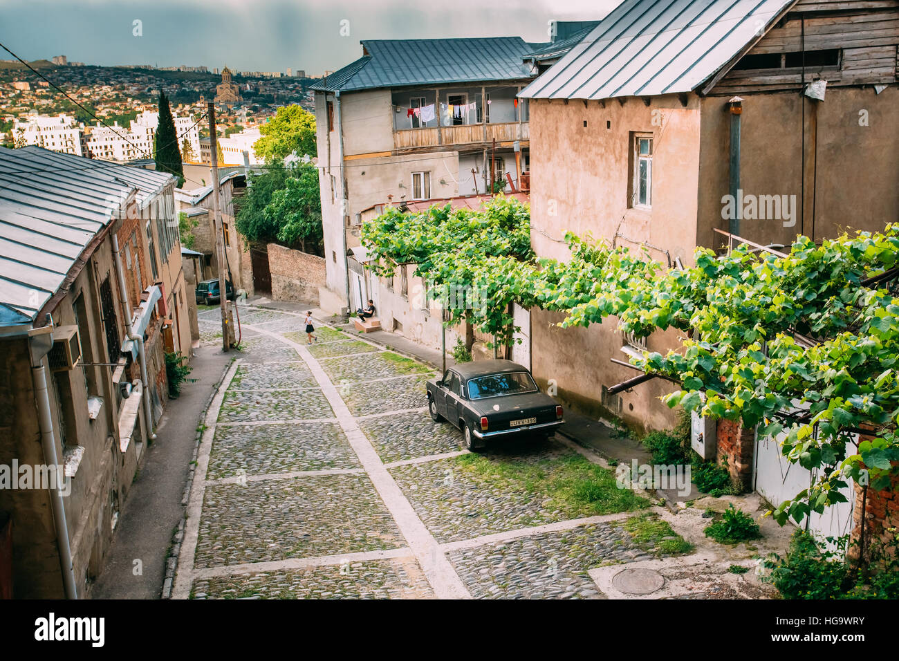 Tbilisi, Georgia - Mayo 20, 2016: Vista superior de Downhill angosta calle adoquinada con negro estacionado Volga GAZ, Retro rareza coche cerca de residencial privado Foto de stock