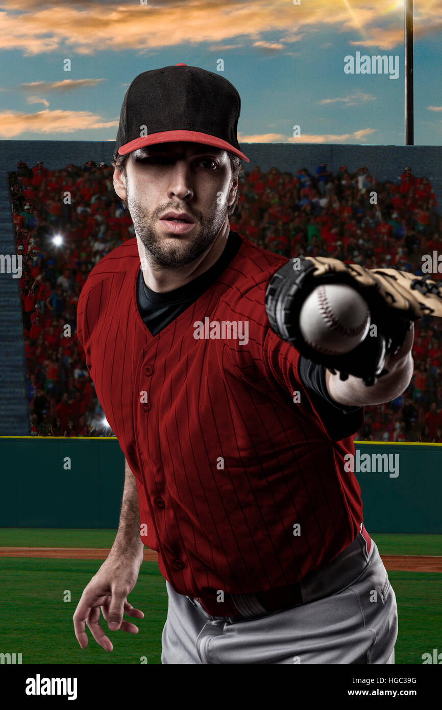 Jugador de béisbol con un rojo uniforme en un estadio de béisbol. Foto de stock