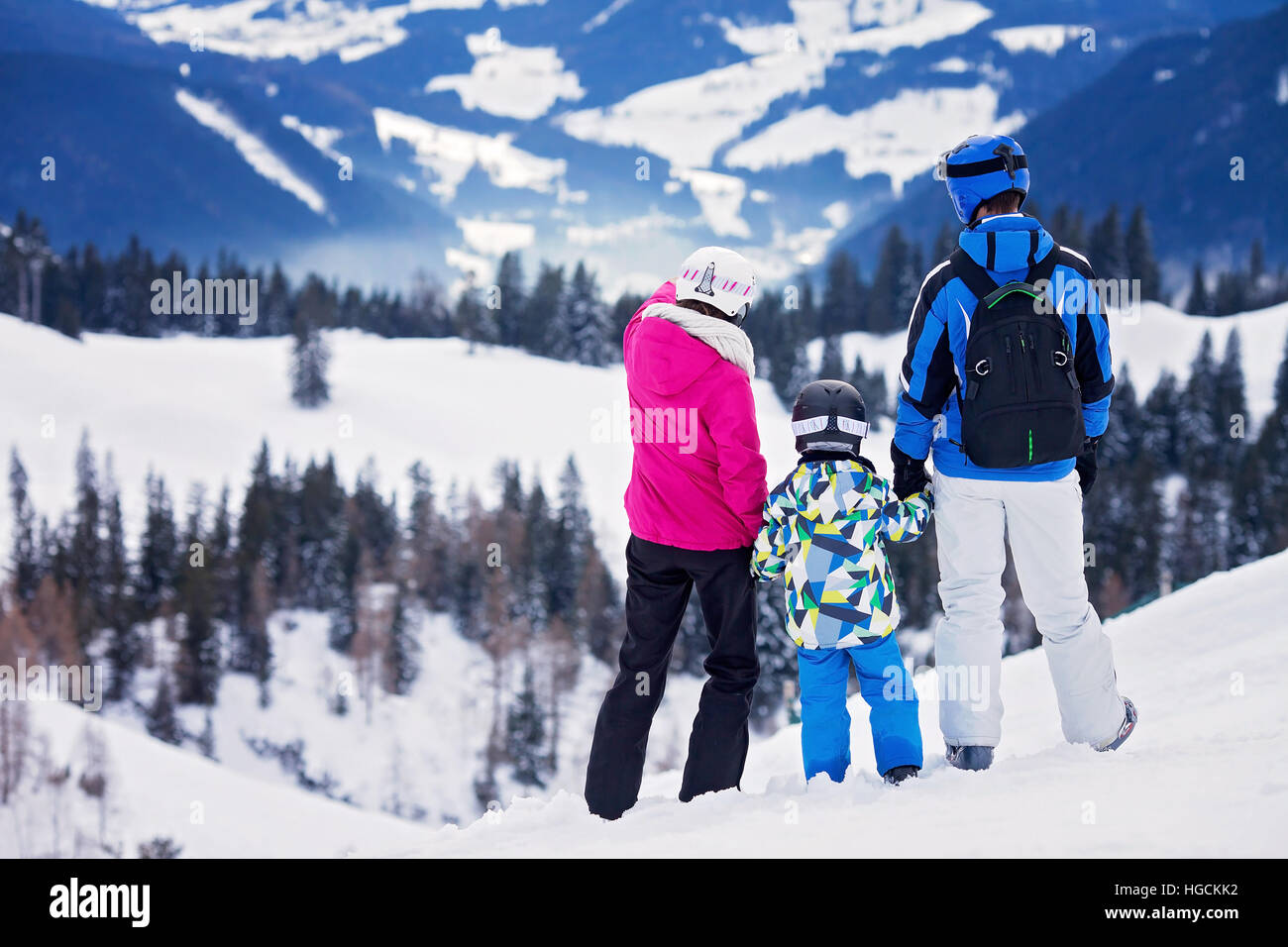 Joven familia feliz con un hijo, esquiar en las montañas, el invierno Foto de stock