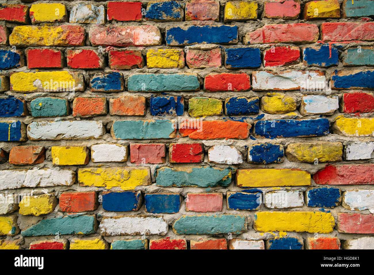 Ladrillos pintado multicolor, una pared exterior como fondo, la trama urbana Foto de stock
