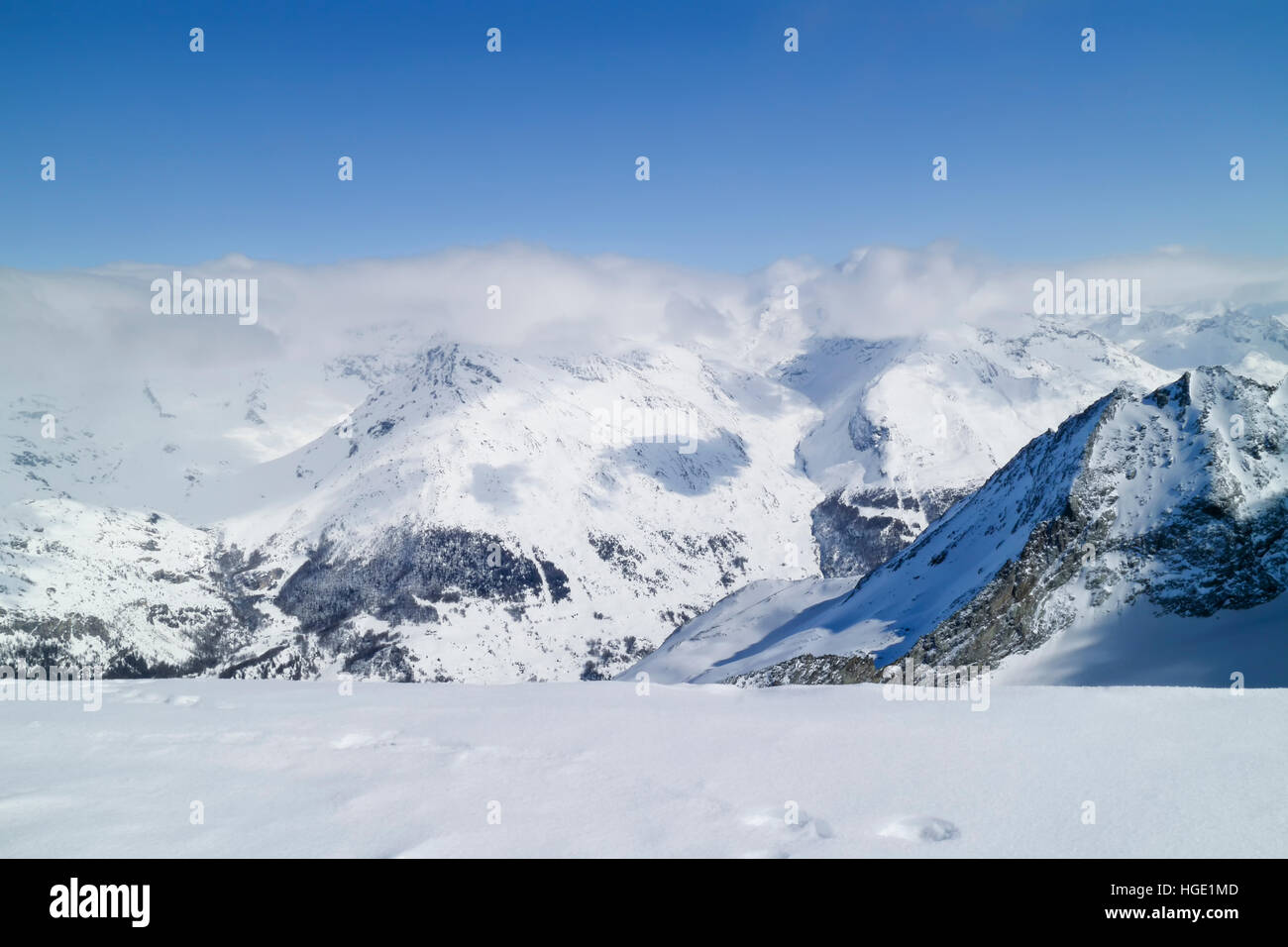 Picos nevados de los Alpes cubiertos por nubes, paisaje invernal, Alpes Franceses Foto de stock