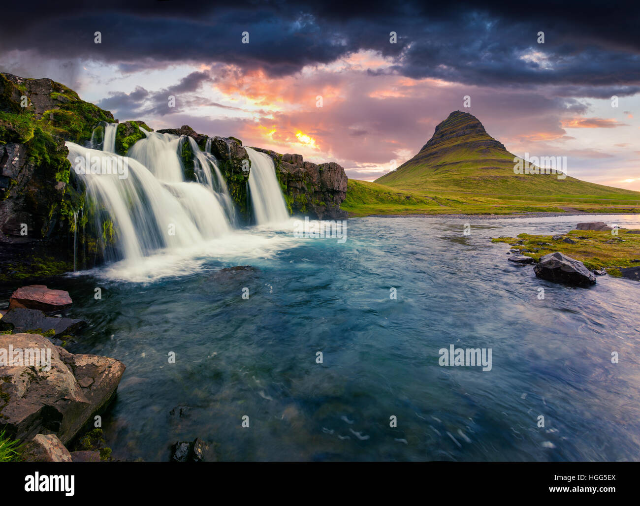 Atardecer de verano en la famosa cascada y montaña Kirkjufell Kirkjufellsfoss. Dramática escena nocturna en la península de Snaefellsnes Foto de stock