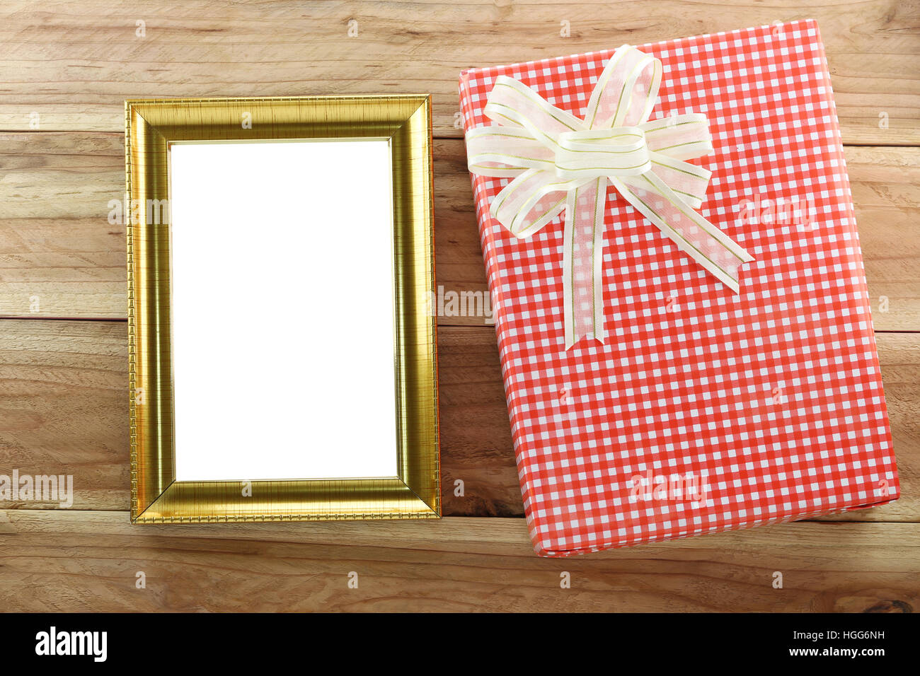 Caja de regalo roja con marco de fotos de madera vacías sobre fondo de madera,concepto de Navidad y día importante. Foto de stock
