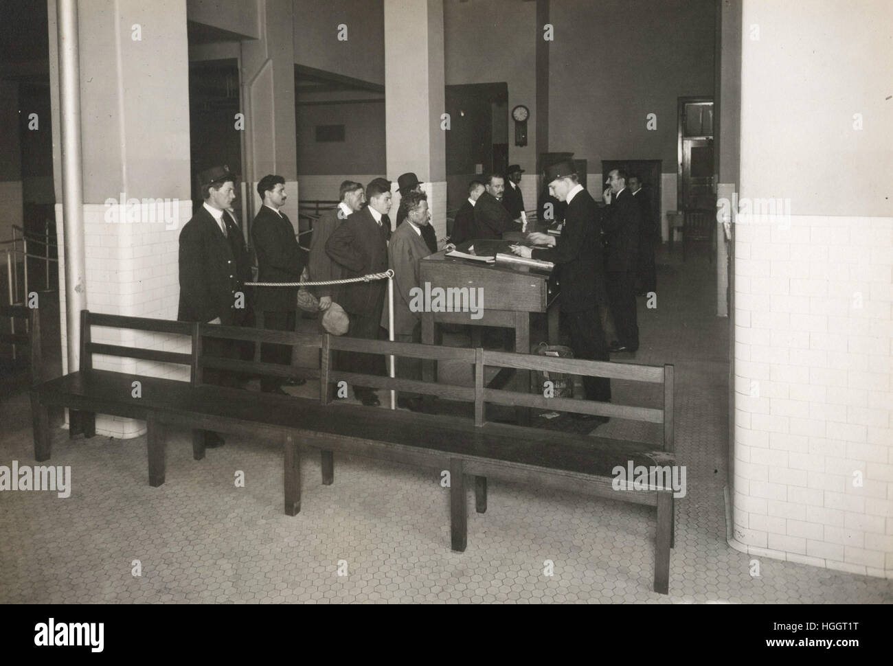 Los inmigrantes esperando en la línea para su procesamiento por parte de funcionarios de la oficina de inmigración. - Ellis Island Immigration Station 1902-1913 Foto de stock