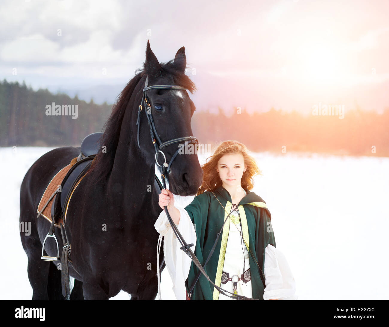 Joven vestido con caballo negro en invierno Foto de stock