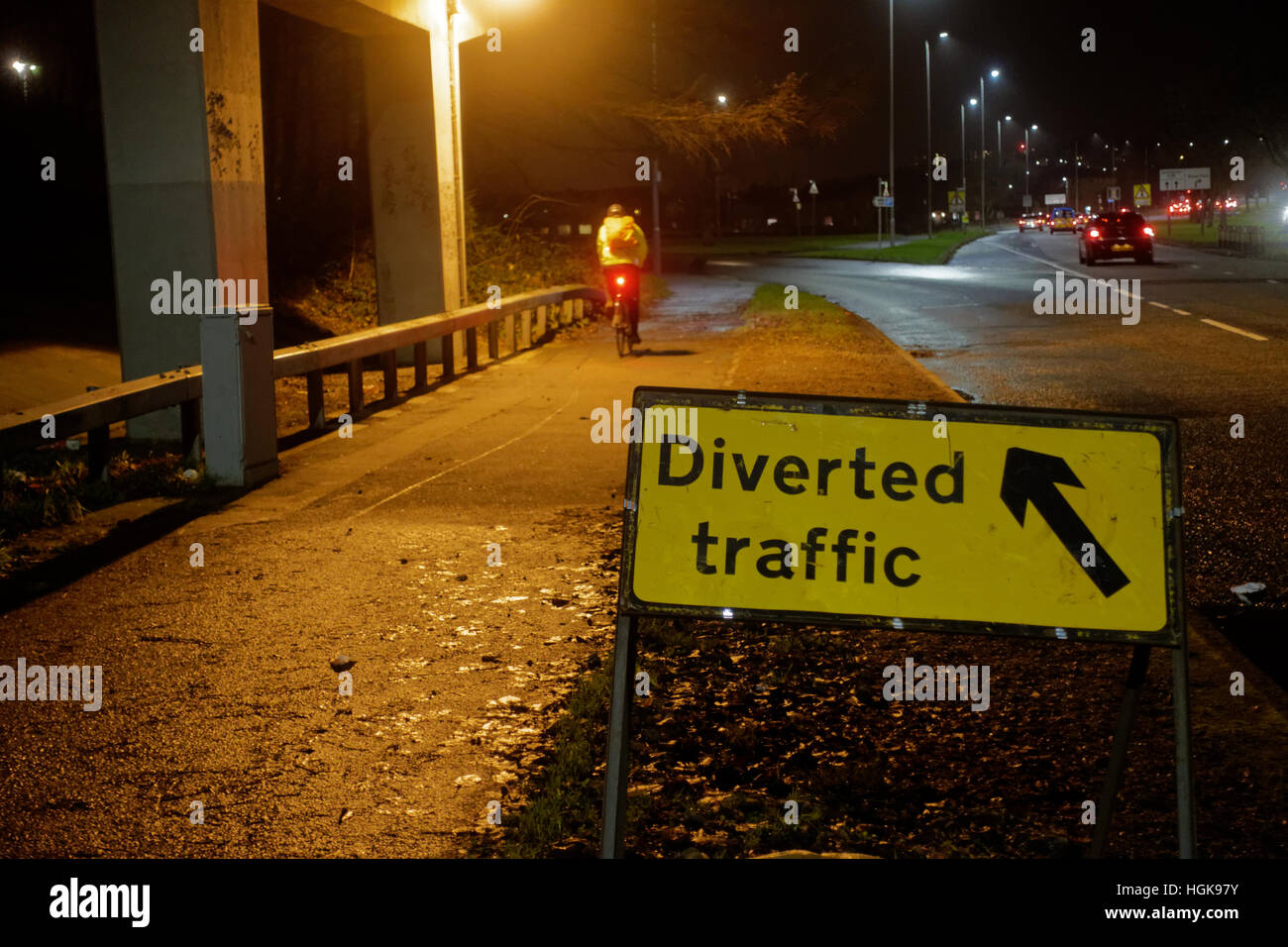 Señal de tráfico desviado con ciclista en bicicleta de noche el tráfico y la Great Western Road Foto de stock