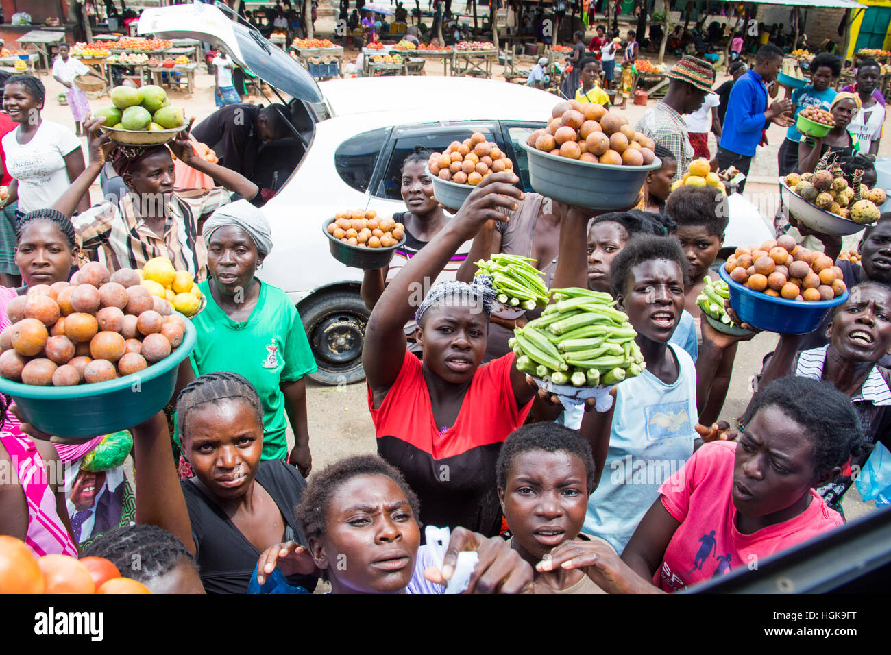 Los vendedores ambulantes de frutas y vegetales venta de frutas a un autobús parado en Zambia Foto de stock