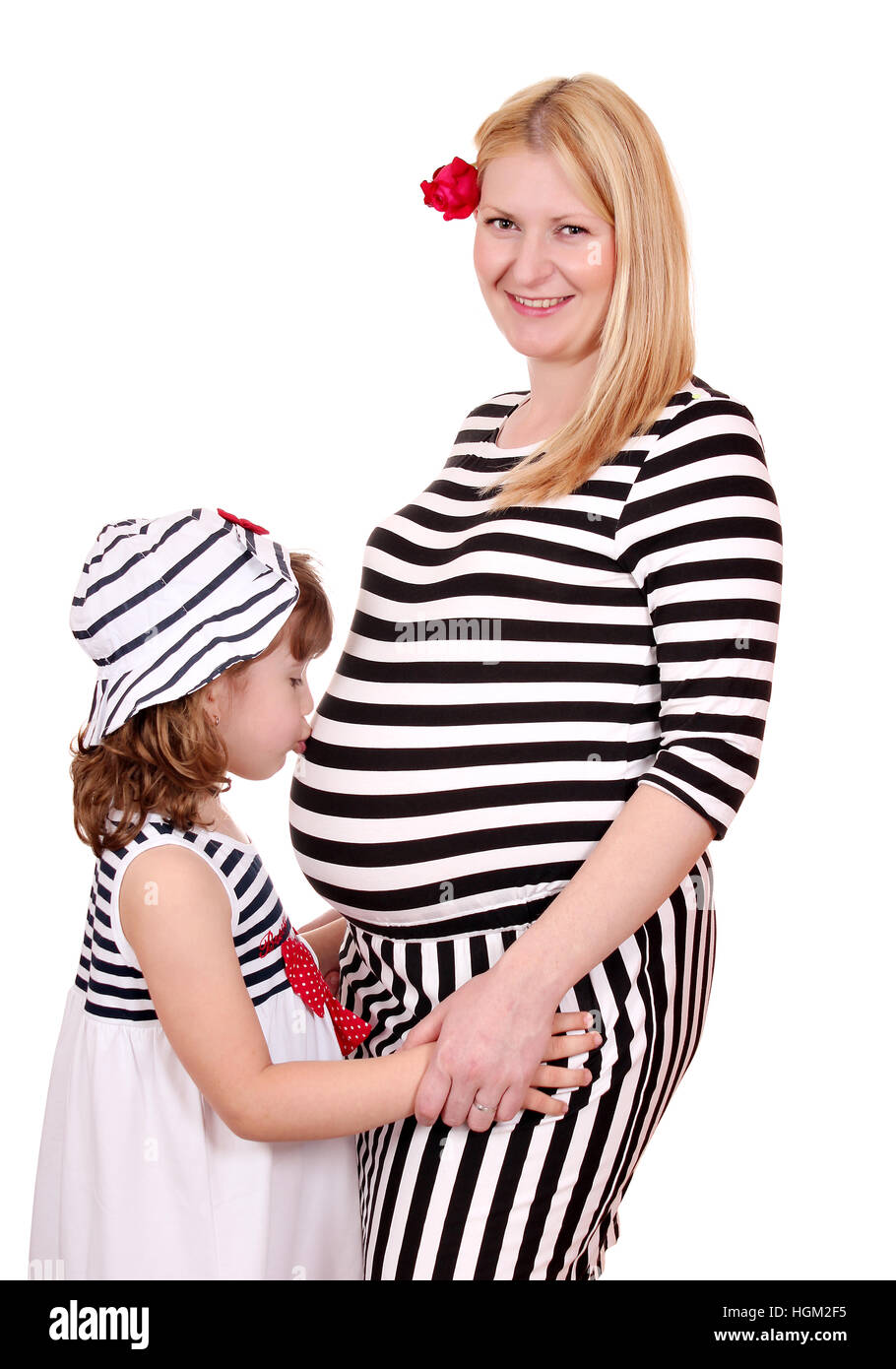 Niña besando el vientre de la madre embarazada Foto de stock