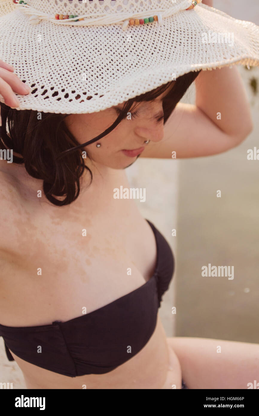 Mujer joven vistiendo un bikini negro en una piscina natural en el verano Foto de stock