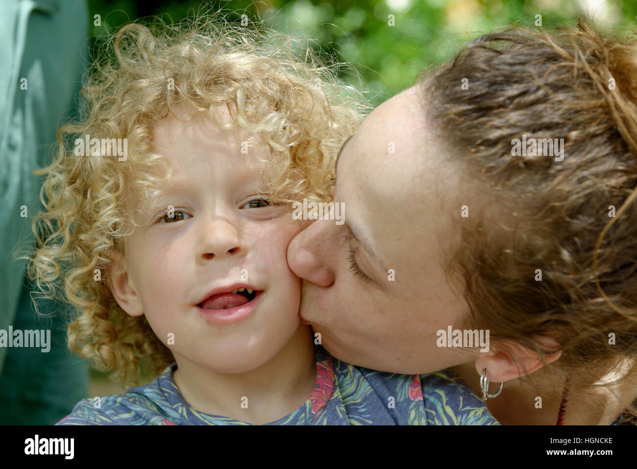 La joven madre besa a su chico Foto de stock