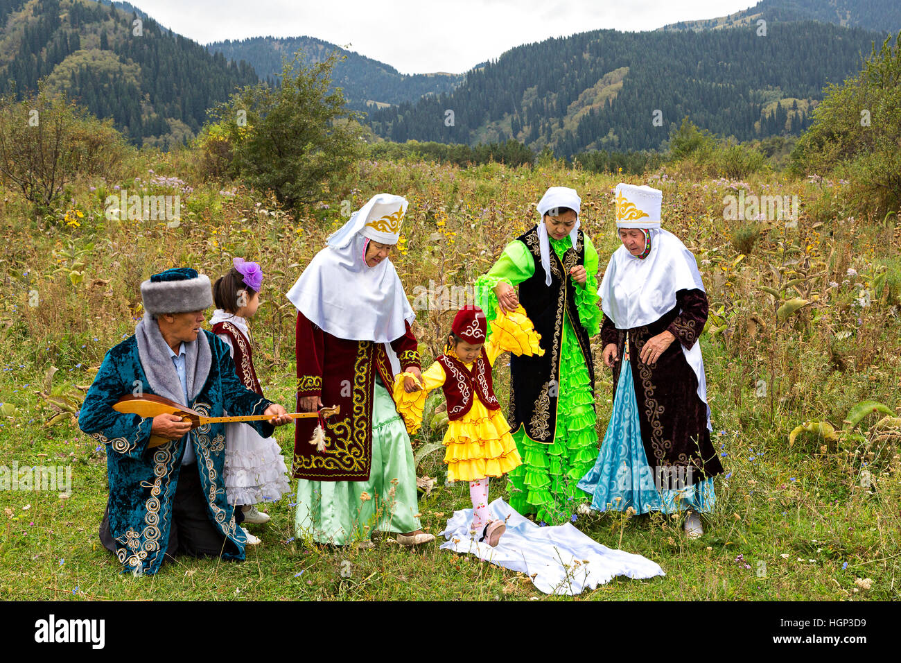 Mujeres kazakas que muestran la tradición local de Tusau Kesu que simboliza una ceremonia que acompaña a los primeros pasos de un niño, en Almaty, Kazajstán Foto de stock