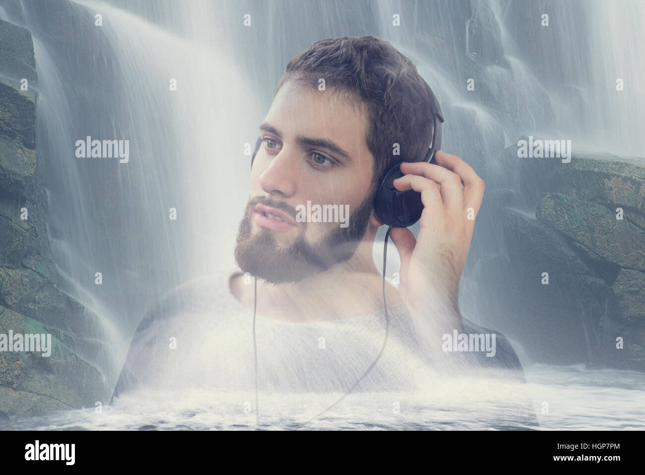 El hombre escucha música de relajación a través de auriculares en la naturaleza en cascada, doble exposición Foto de stock