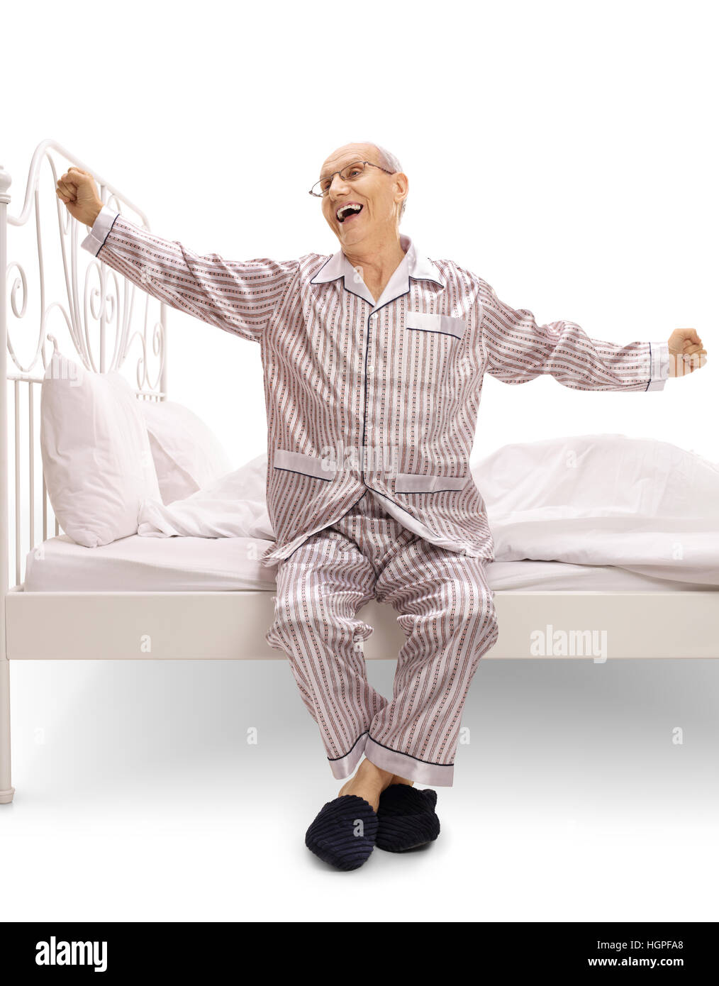 Anciano en pijama sentado en una cama y el bostezo aislado sobre fondo  blanco Fotografía de stock - Alamy