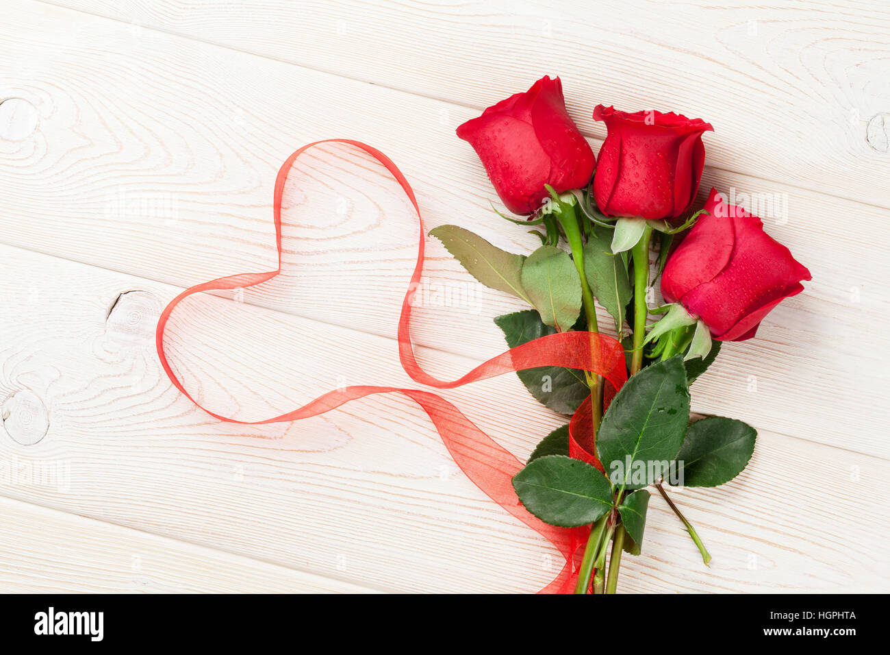Forma de corazón hecha con pétalos de rosas rojas naturales