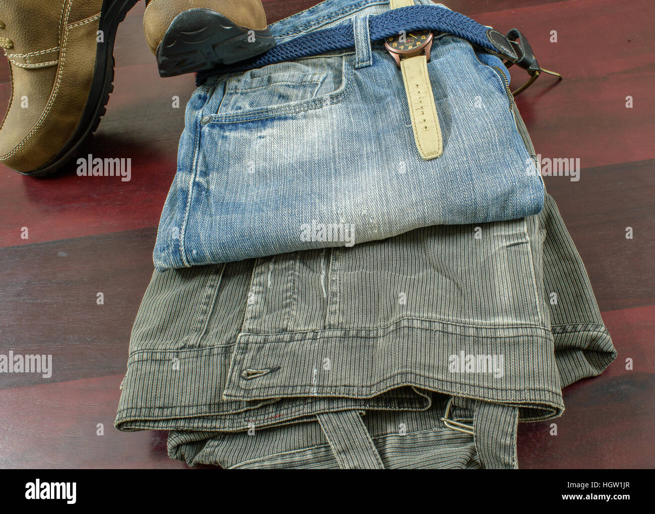 Moda hombre robusto con pantalones vaqueros chaqueta Correa de reloj y  zapatos de cuero de gamuza marrón sobre fondo de madera Fotografía de stock  - Alamy