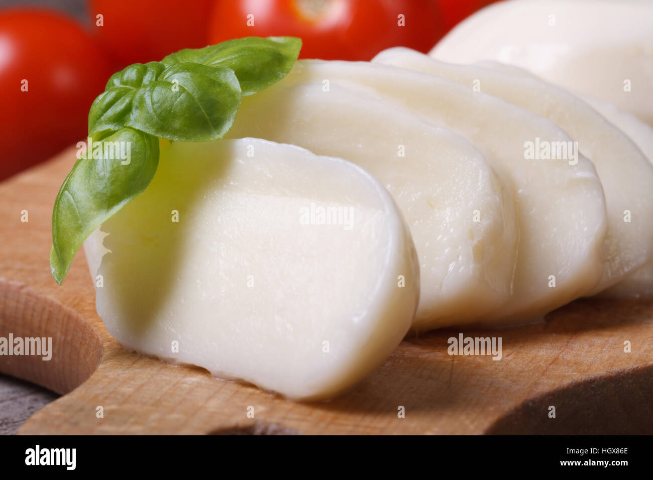Macro lonchas de queso mozzarella con albahaca en placa de cocina Foto de stock
