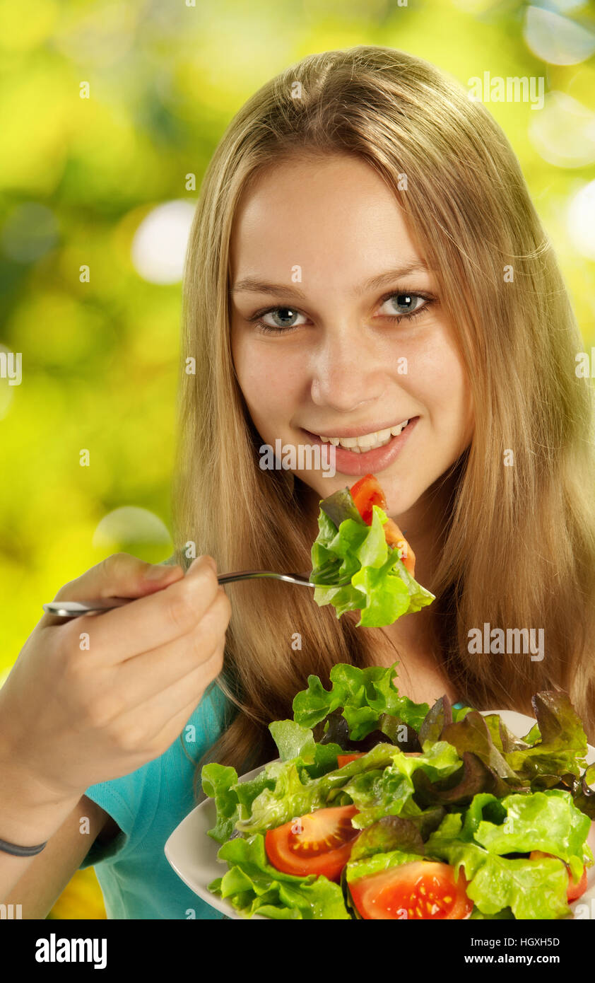 Joven, bonita mujer comer ensalada Foto de stock