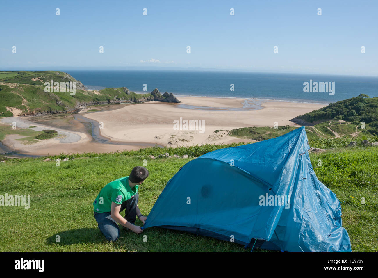 Joven lanzando una tienda de campaña en un camping cerca de la playa  Fotografía de stock - Alamy