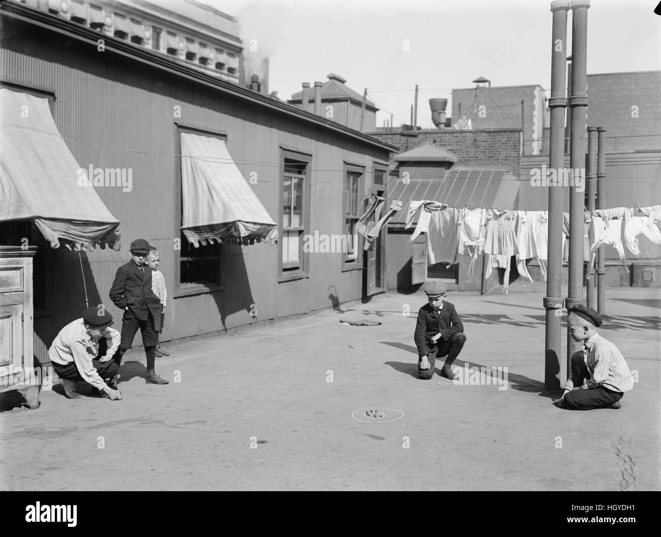 Niños jugando a las canicas en edificio de apartamentos, en la azotea de la ciudad de Nueva York, Nueva York, EE.UU., el Servicio de Noticias Bain, 1910 Foto de stock