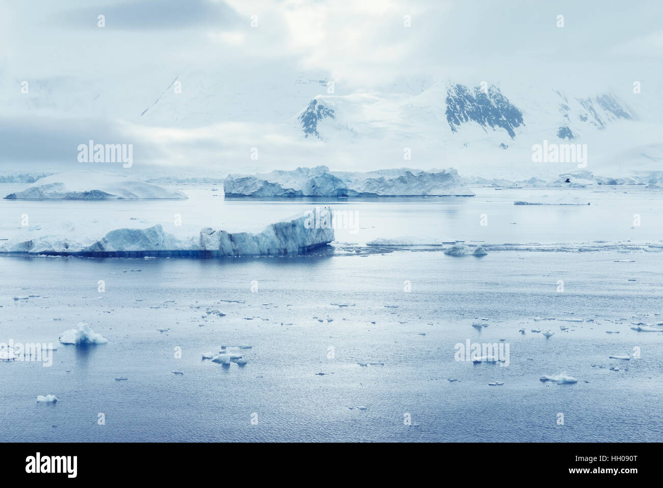 Las nubes bajas sobre las montañas y los trozos de hielo flotante de Puerto Lockroy Research Station, en la Antártida, Polar Foto de stock