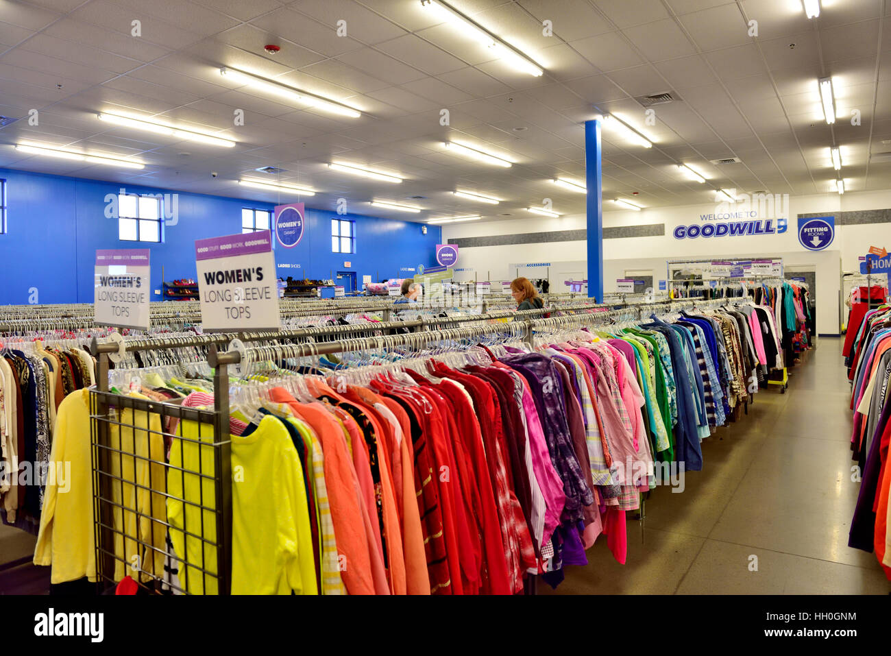 Rack de coloridas camisas de mujer a la venta en una tienda de Buena Voluntad Foto de stock