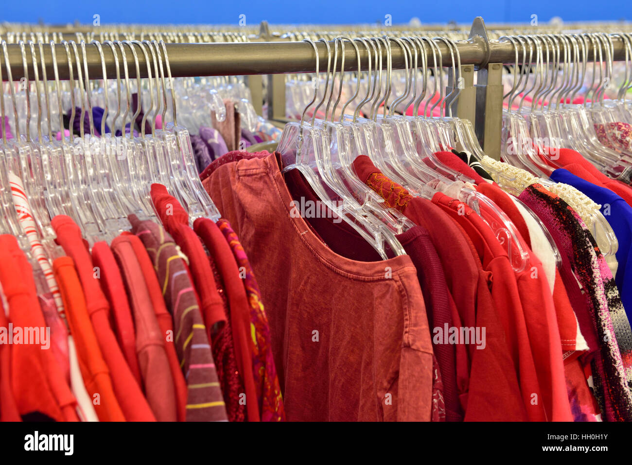 Rack de colorido rojo camisas de mujer a la venta en la tienda Foto de stock