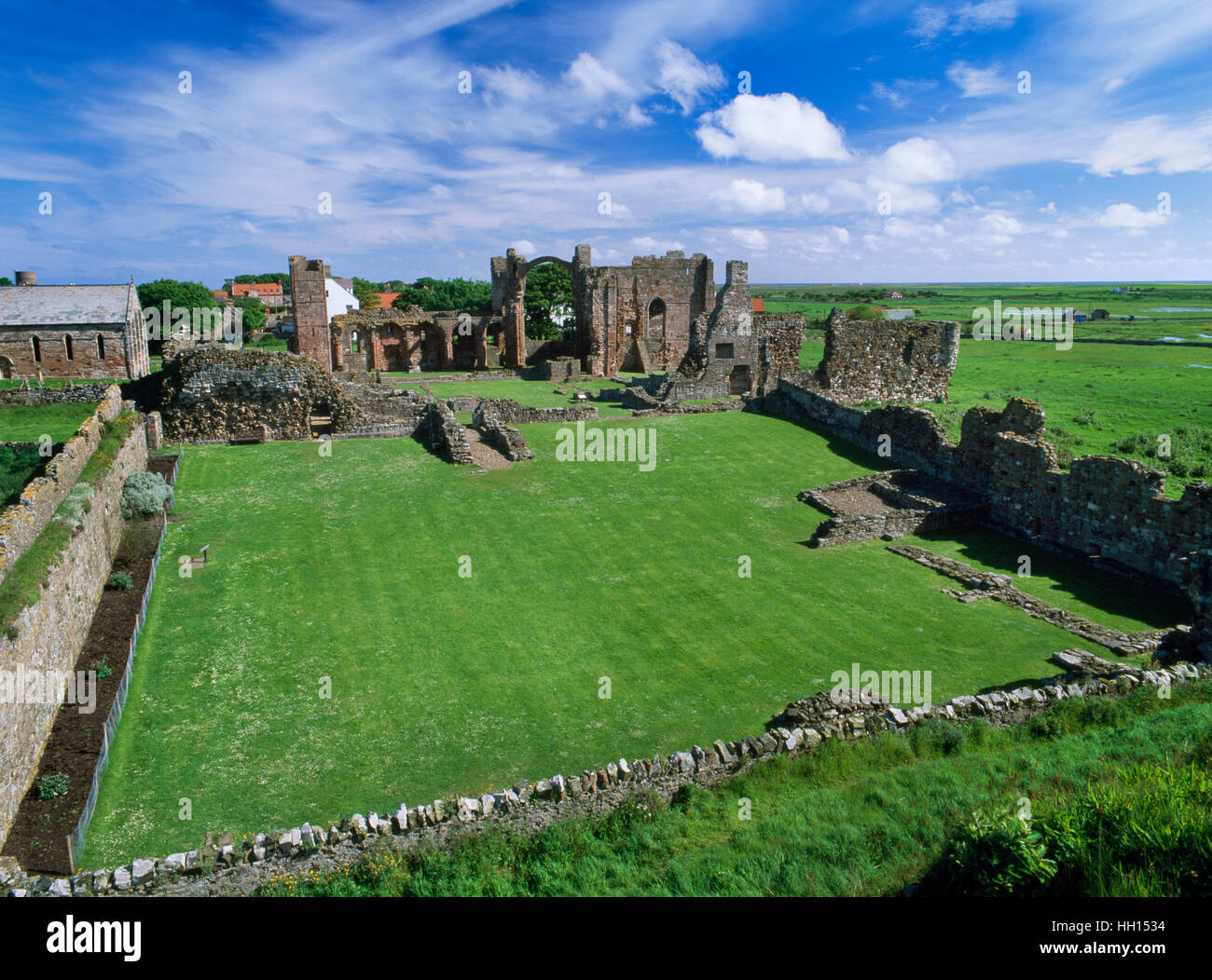 Lindisfarne Priory, Holy Island. Ver N a través de la cancha exterior & claustro a iglesia monástica con W frontal (L) y el centro de arco iris. Foto de stock