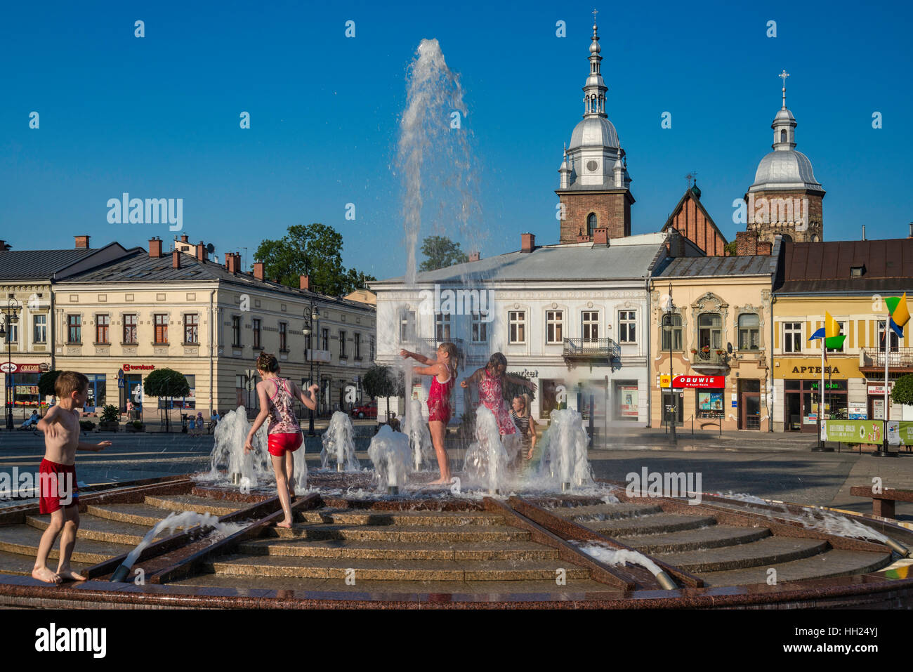 Niños jugando en la fuente papal en los calurosos días de verano, el Rynek (Plaza del Mercado) en Nowy Sacz, Malopolska, Polonia Foto de stock