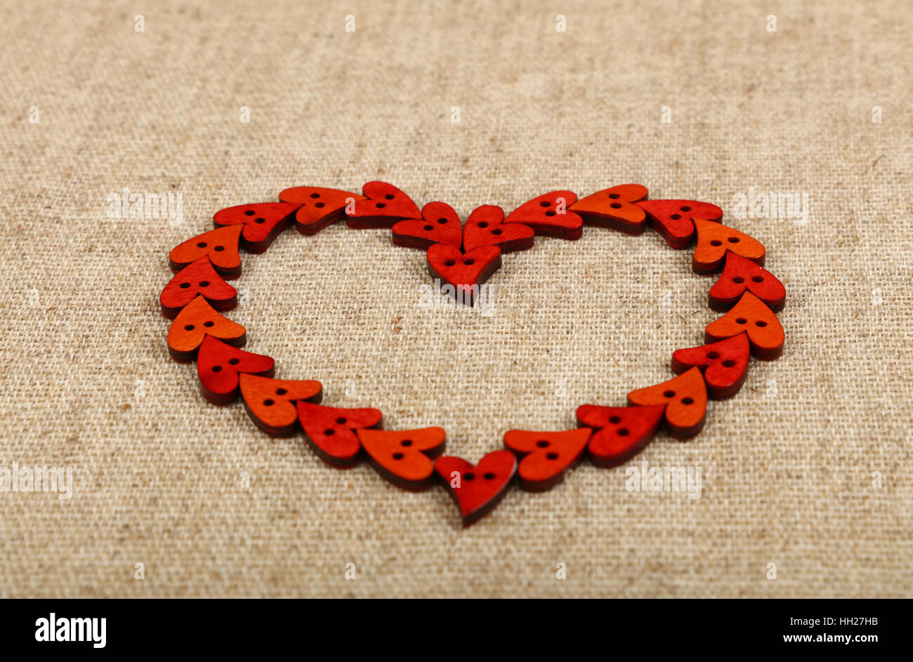 Rojo de madera artesanales en forma de corazón cosiendo botones bastidor  sobre lienzo de lino, vista de ángulo bajo, cerrar Fotografía de stock -  Alamy