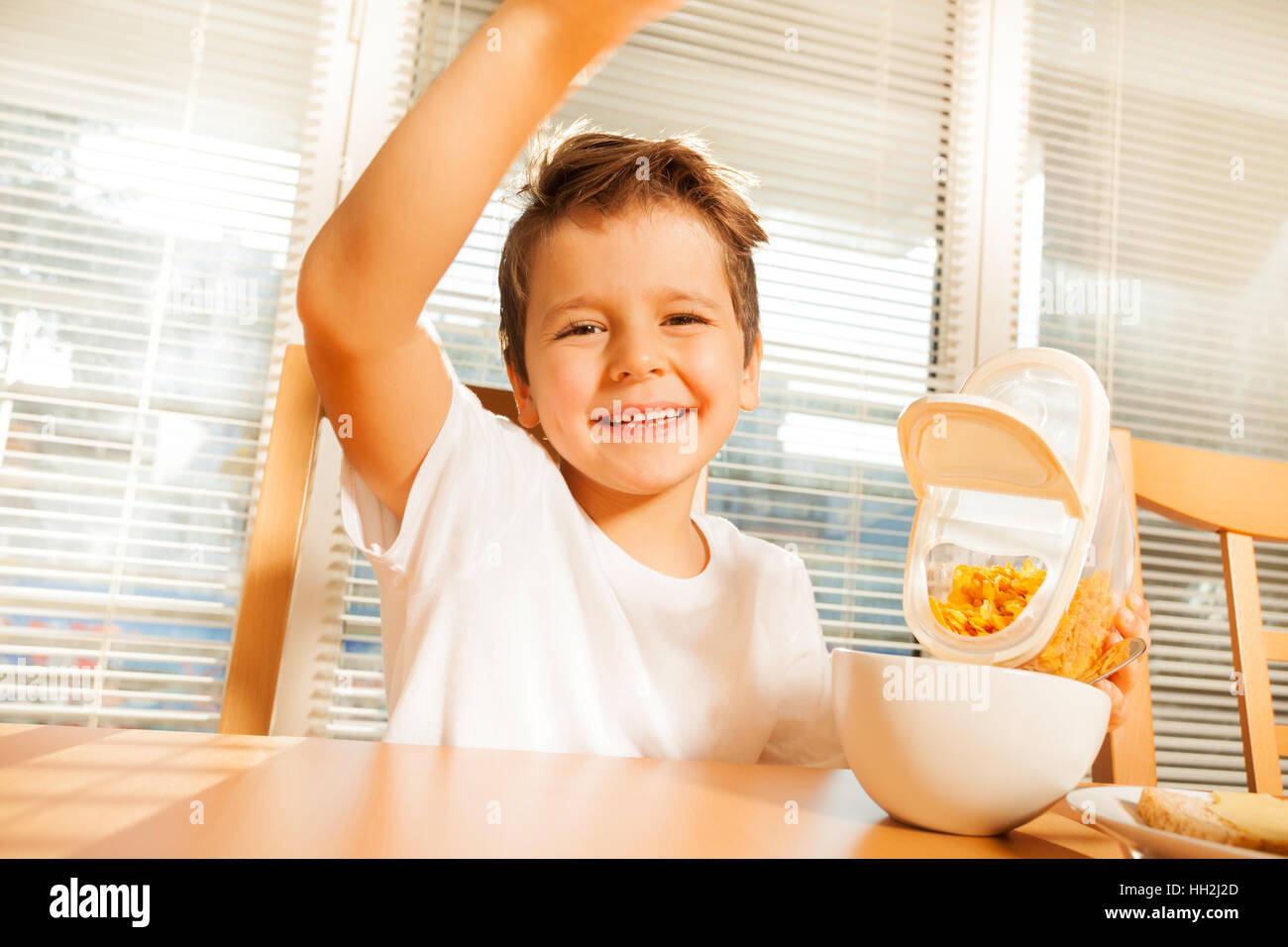 Muchacho feliz haciendo el desayuno en la cocina Foto de stock