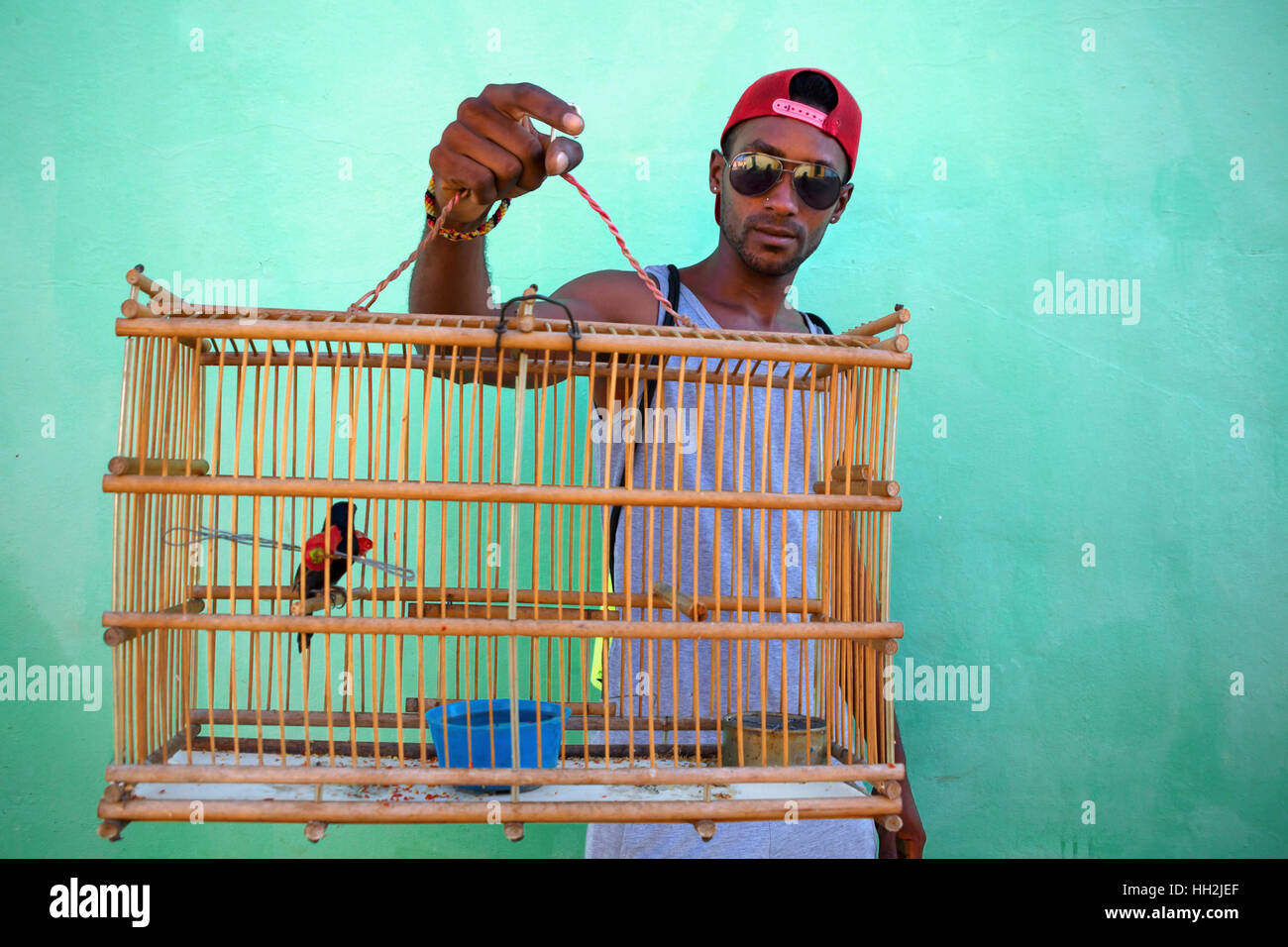 Retrato del hombre cubano portando una jaula con pájaro dentro en Trinidad, Cuba Foto de stock