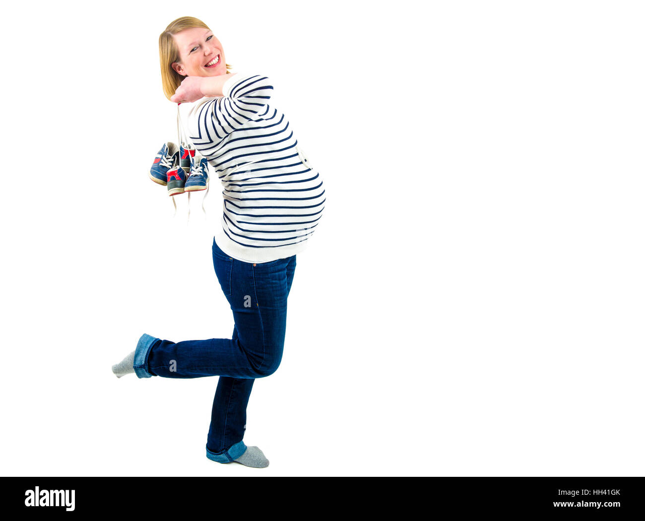 Mujer embarazada esperando gemelos y sonriente sosteniendo par de zapatos  de bebé. Aislado en blanco para su logotipo o texto. Embarazo saludable y  feliz lifesty Fotografía de stock - Alamy