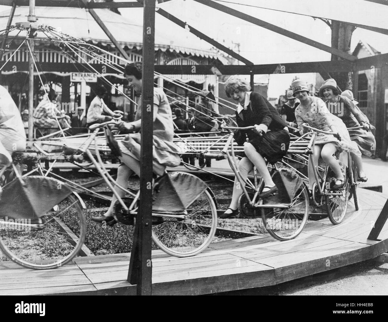 Las mujeres jóvenes divirtiéndose en un ciclismo tiovivo de Southend Foto de stock