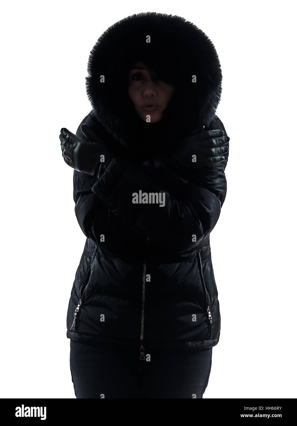 Una Mujer con abrigo de invierno frío silueta sobre fondo blanco. Foto de stock
