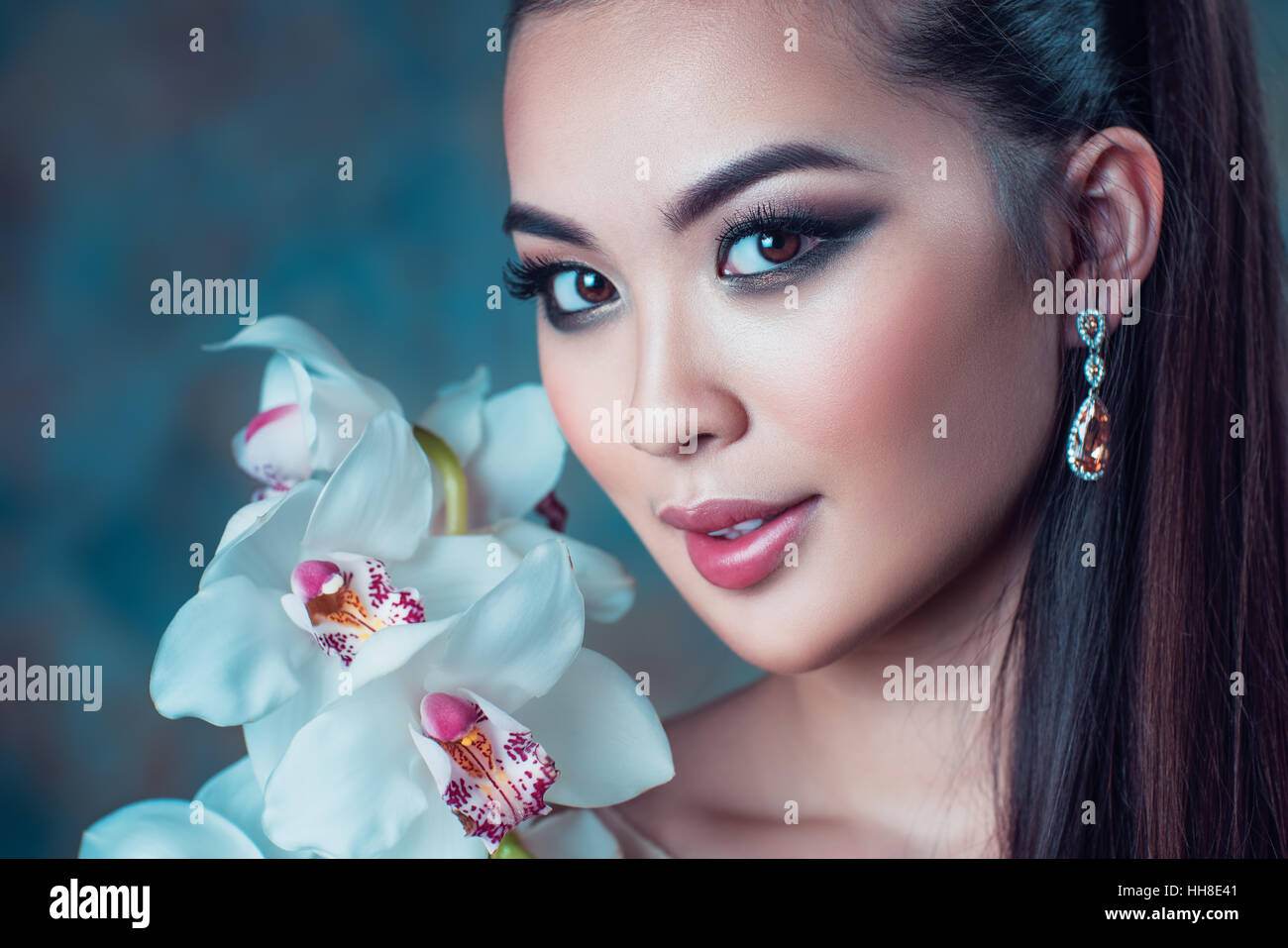 Joven mujer asiática con flor de orquídea retrato Foto de stock