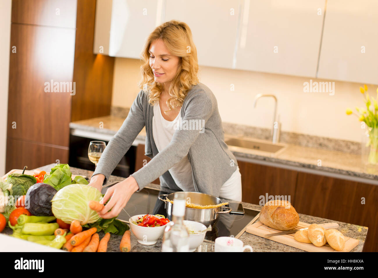 Mujer joven cocinar alimentos saludables en la cocina moderna Foto de stock