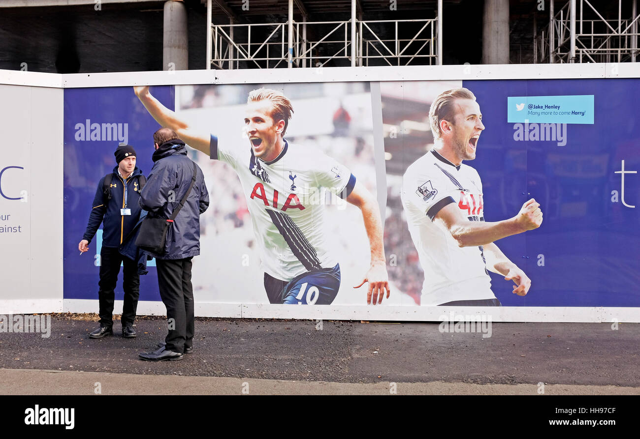 Los hombres charlando uno fumar un cigarrillo fuera de White Hart Lane la construcción del nuevo estadio de Tottenham Hotspur FC con pósters de Harry Kane Foto de stock
