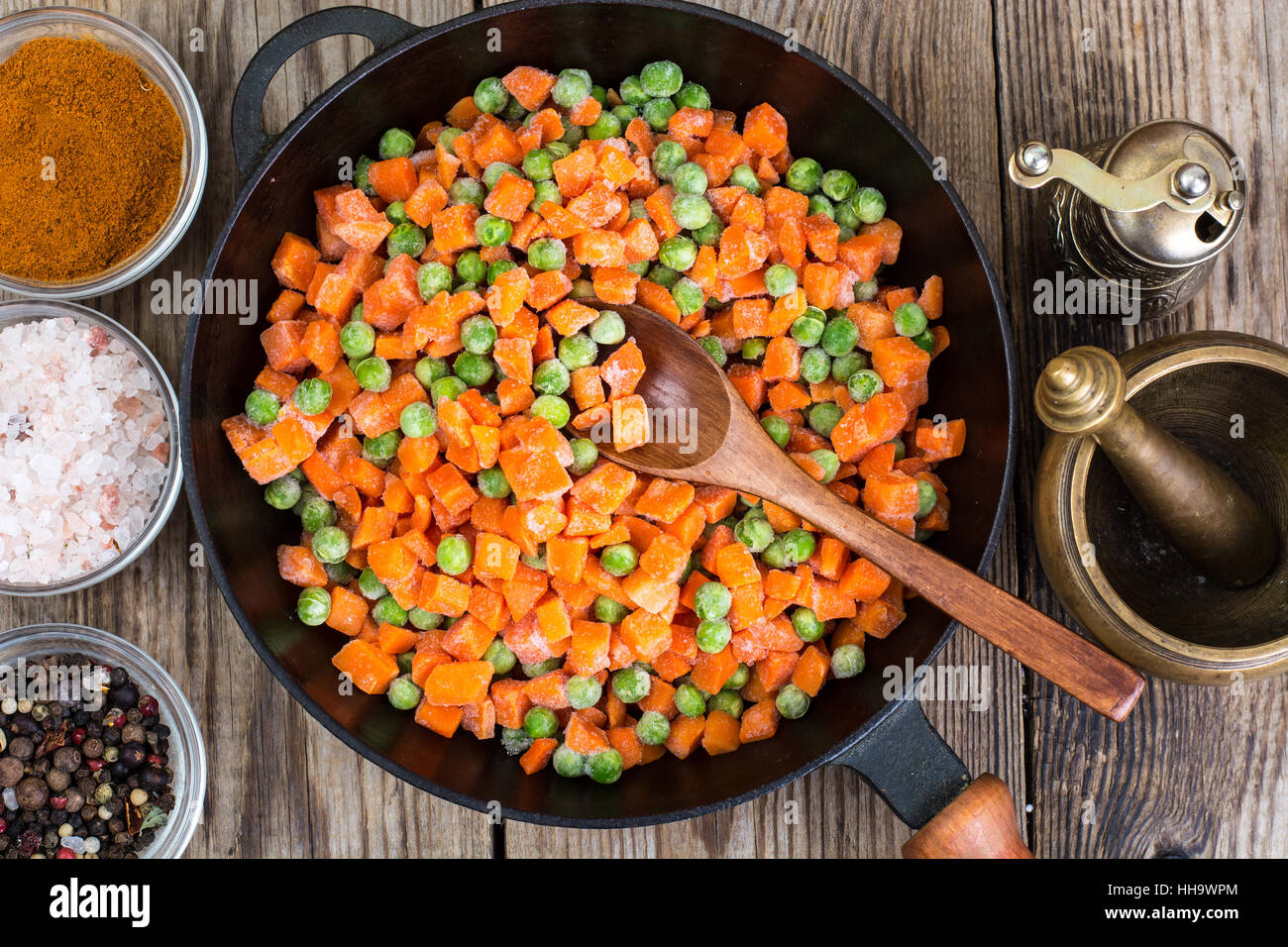 Los guisantes congelados y zanahorias para cocinar en una sartén Fotografía  de stock - Alamy