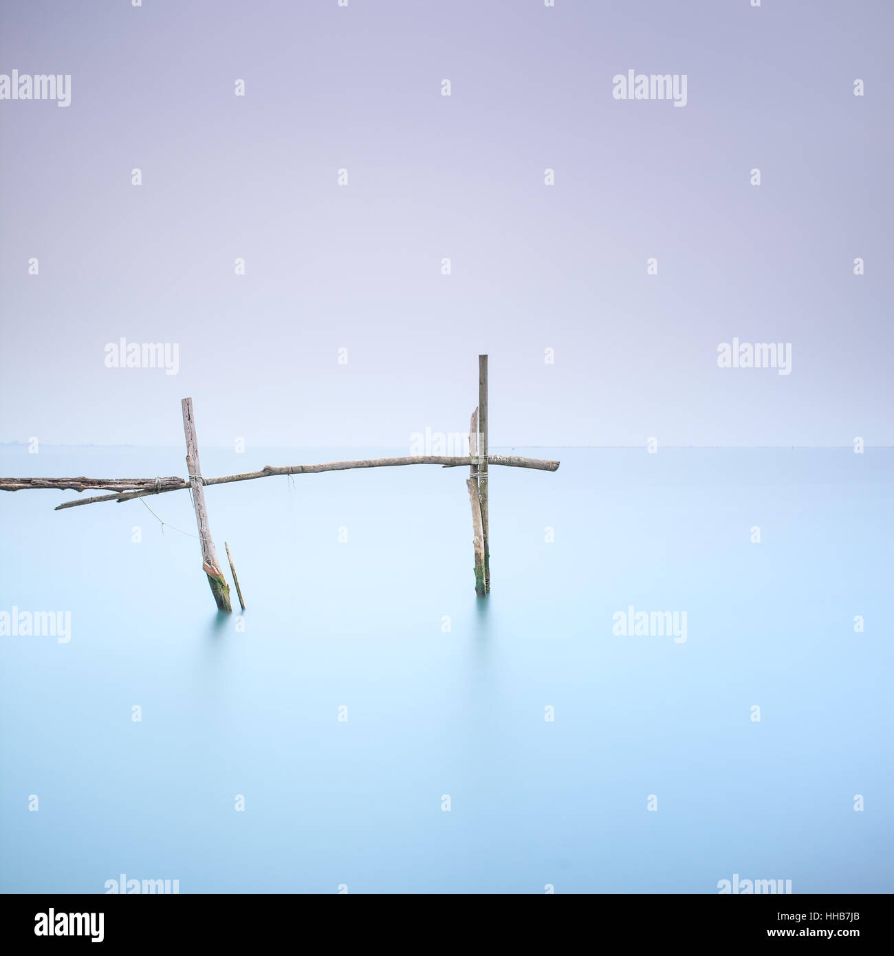Cañas de pescar para las almejas y los mejillones y agua blanda en un tranquilo paisaje neblinoso. La larga exposición fotografía Foto de stock