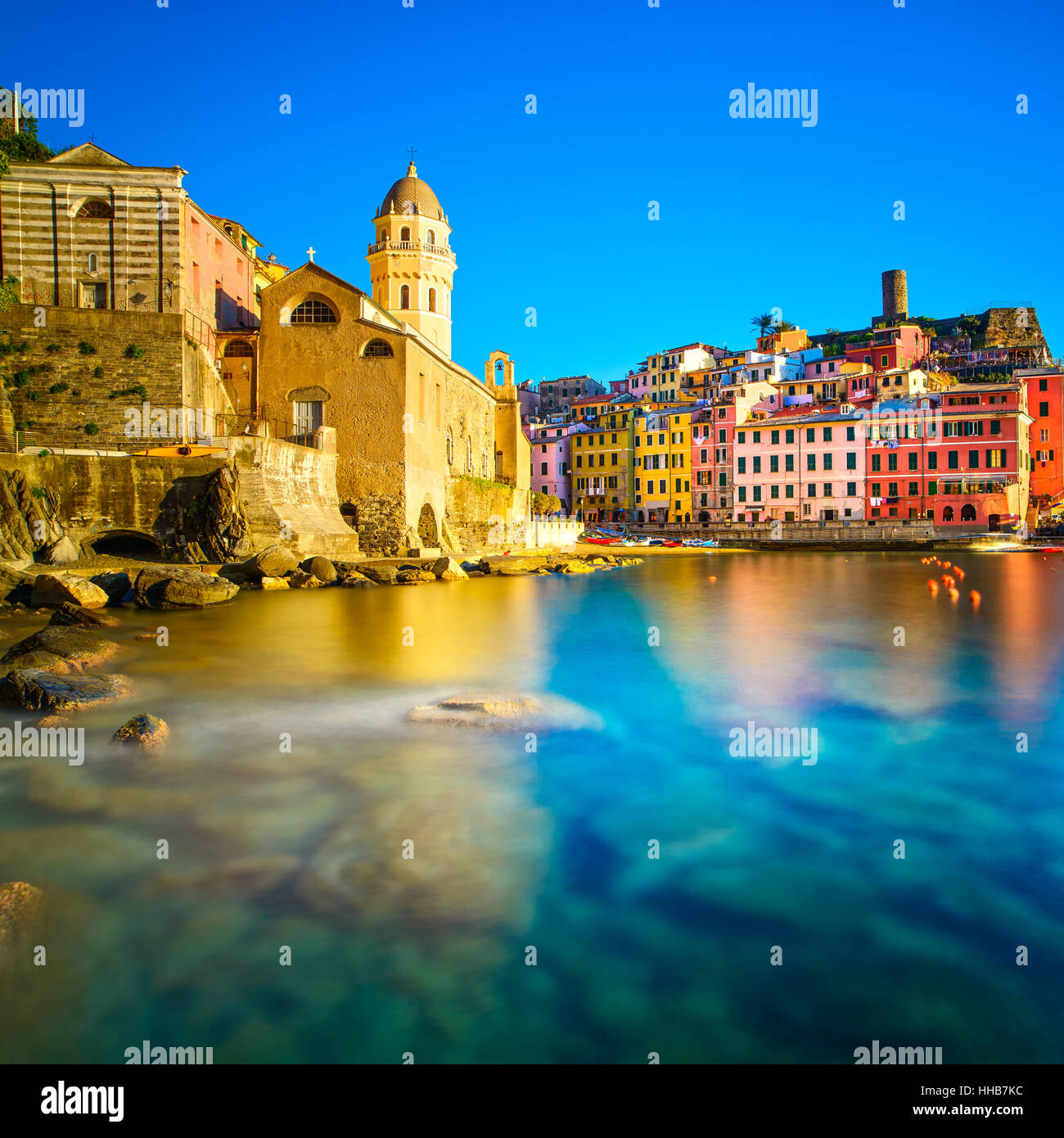 Vernazza village, iglesia, rocas y puerto de mar en el atardecer, Seascape en cinco tierras, el Parque Nacional de Cinque Terre, Liguria Italia Europa. La larga exposición. Foto de stock