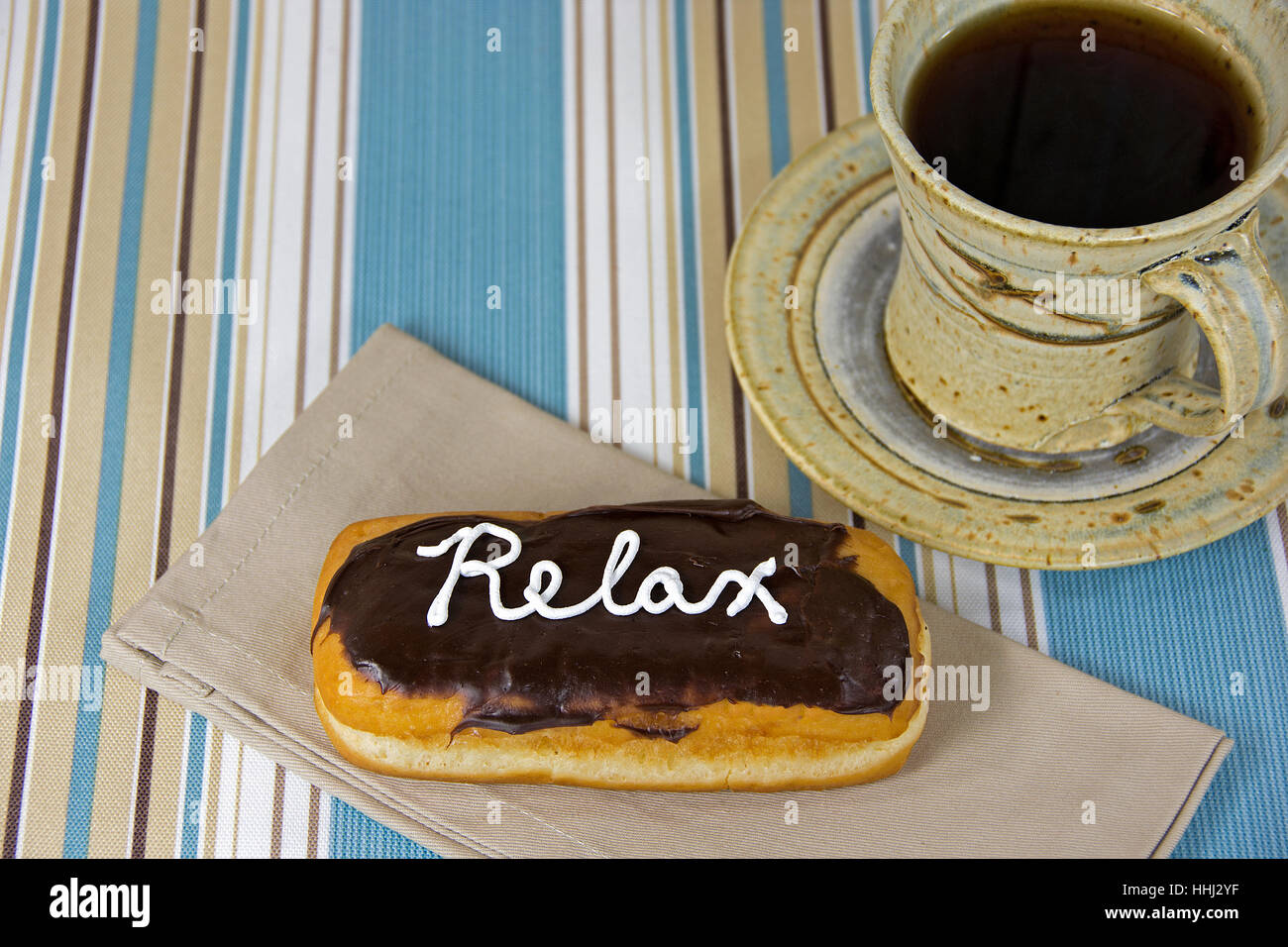Palabra relajarse en blanco guinda donut de chocolate con café negro en taza Foto de stock