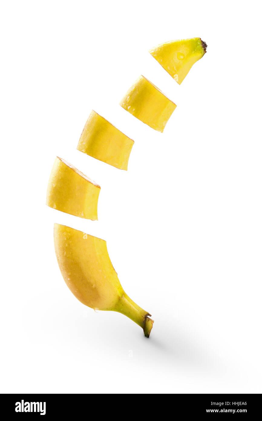 Rodajas de plátano volando sobre fondo blanco. Foto de stock