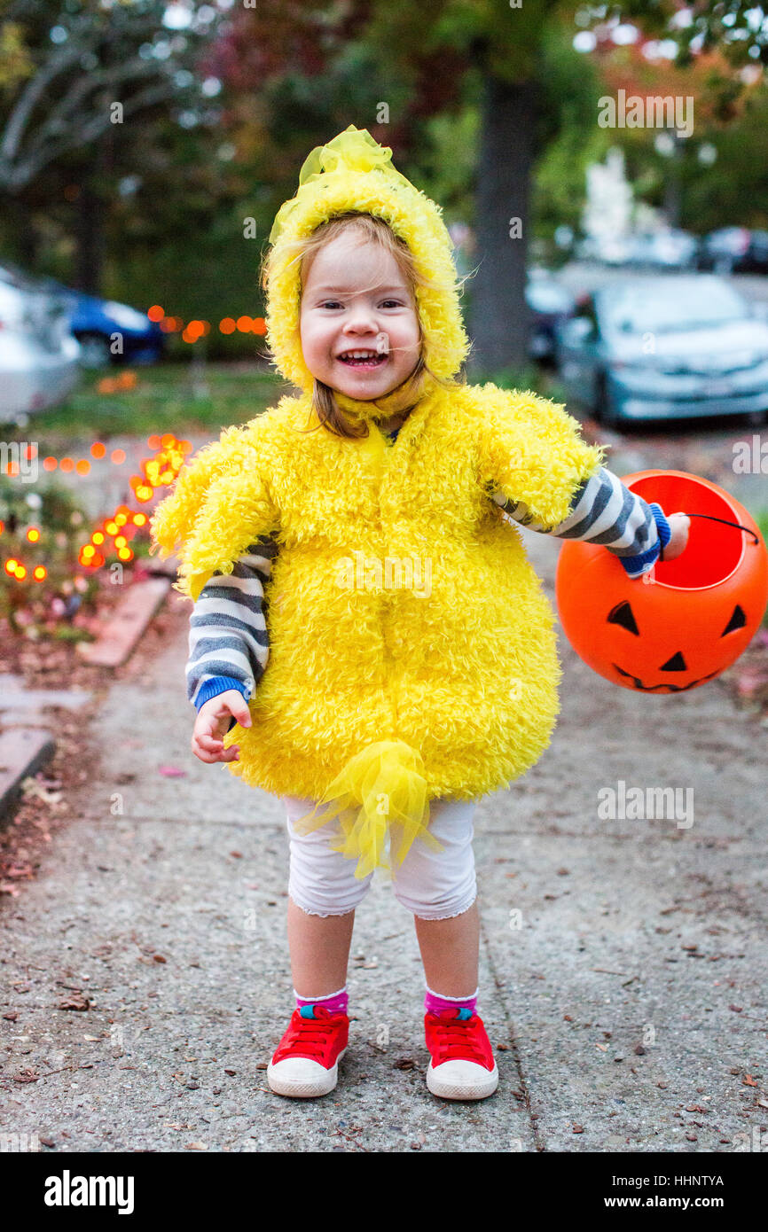 Sonriente niña caucásica vistiendo trajes de pollo en Halloween Foto de stock