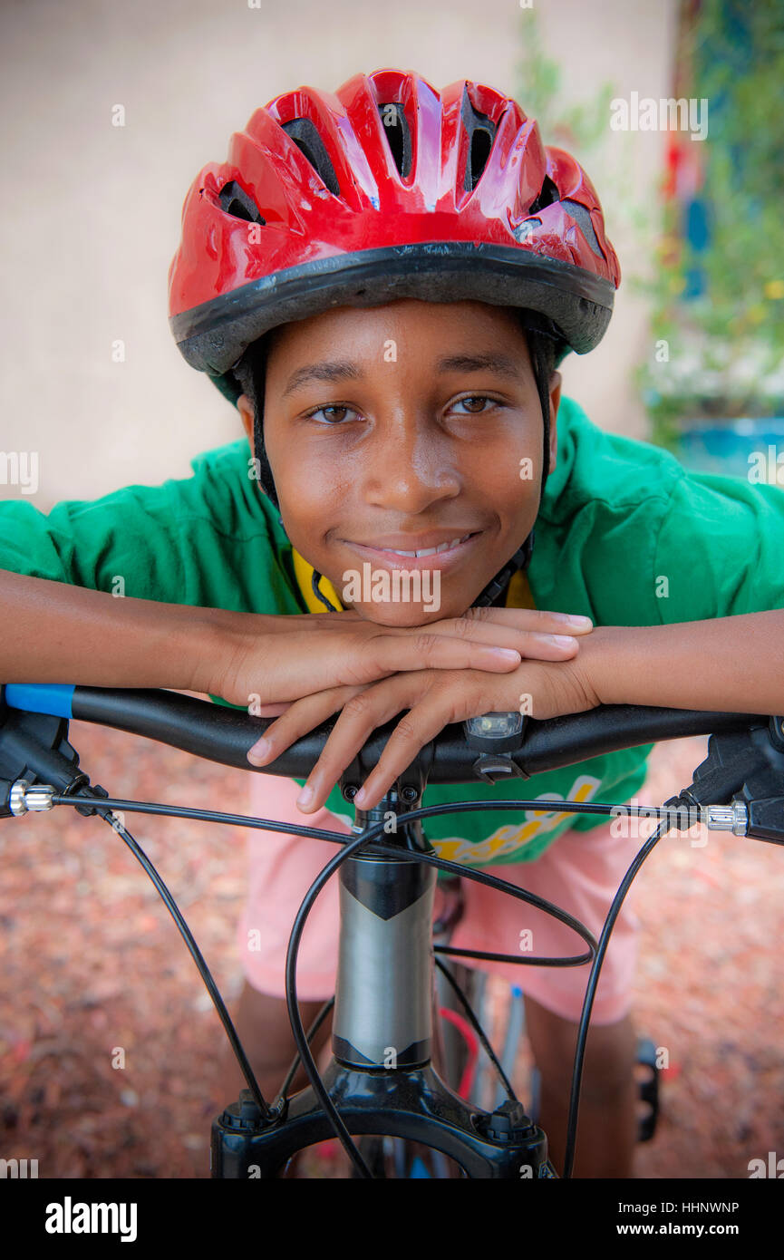 Un niño de 2 años aprende a andar en bicicleta de equilibrio en la  carretera de la aldea en la primavera