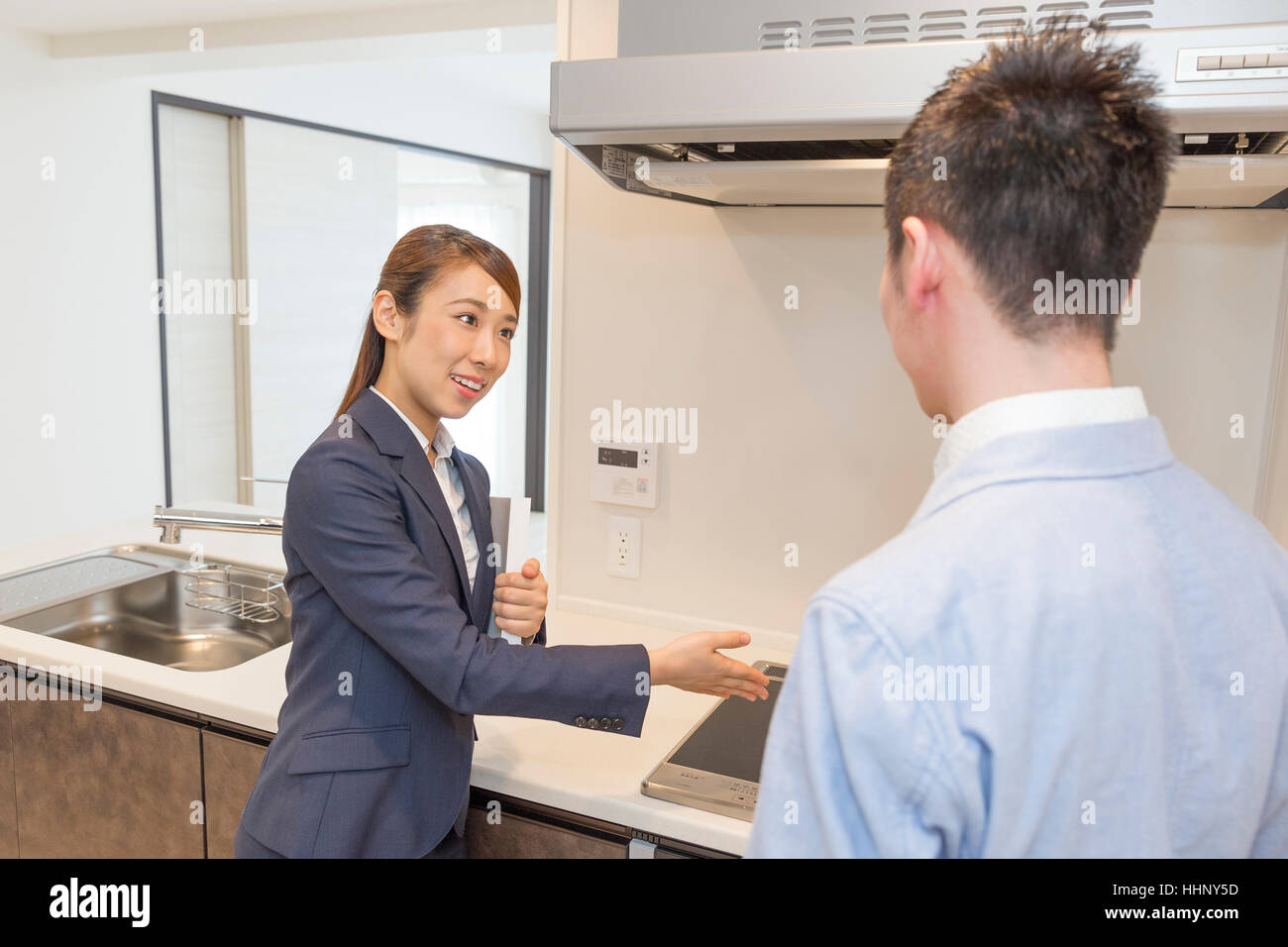 Agente Inmobiliario mostrando cocina al comprador Foto de stock