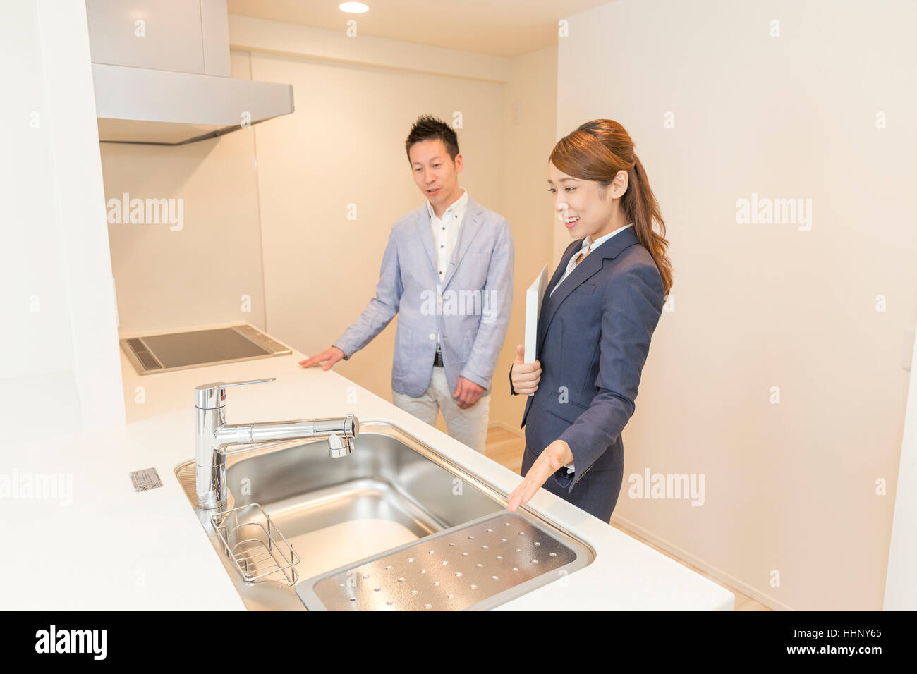 Agente Inmobiliario mostrando cocina al comprador Foto de stock