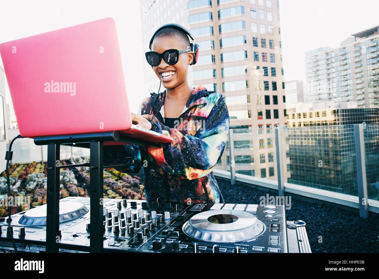 Sonriente DJ Negro en la azotea urbana Foto de stock